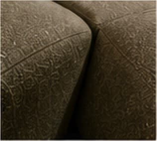 Close view of a rounded seat seam in olive woven fabric.